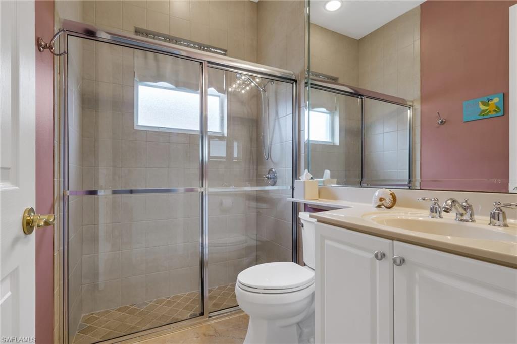 9348 Sun River Way Estero, FL 33928 - Photo 22 of 38 a bathroom with a shower sink vanity and toilet