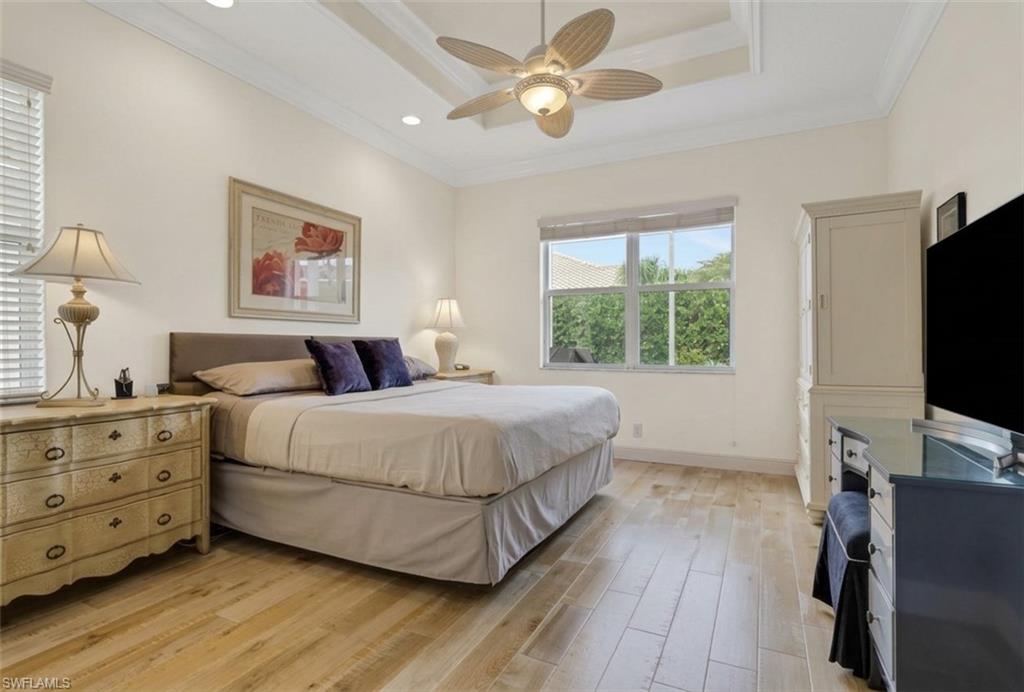 9348 Sun River Way Estero, FL 33928 - Photo 26 of 50 Bedroom featuring crown molding, light wood-style flooring, ceiling fan, and a raised ceiling