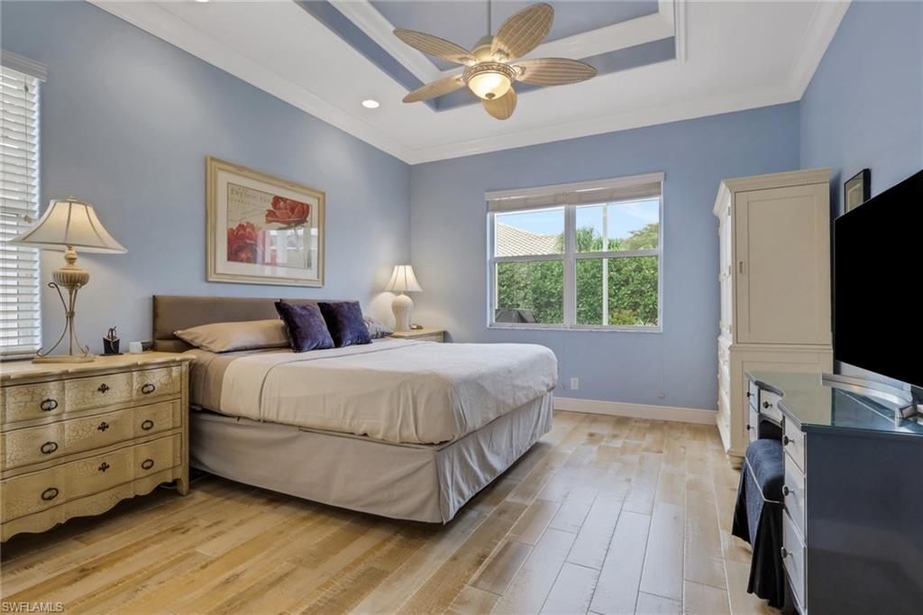 9348 Sun River Way Estero, FL 33928 - Photo 27 of 50 Bedroom with light wood-style flooring, ornamental molding, ceiling fan, recessed lighting, and a raised ceiling