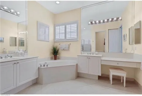a bathroom with a tub sink and mirror