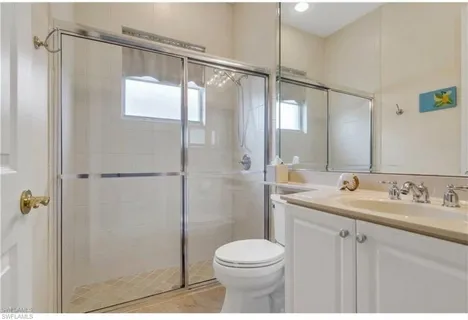 a bathroom with a shower sink vanity mirror and toilet