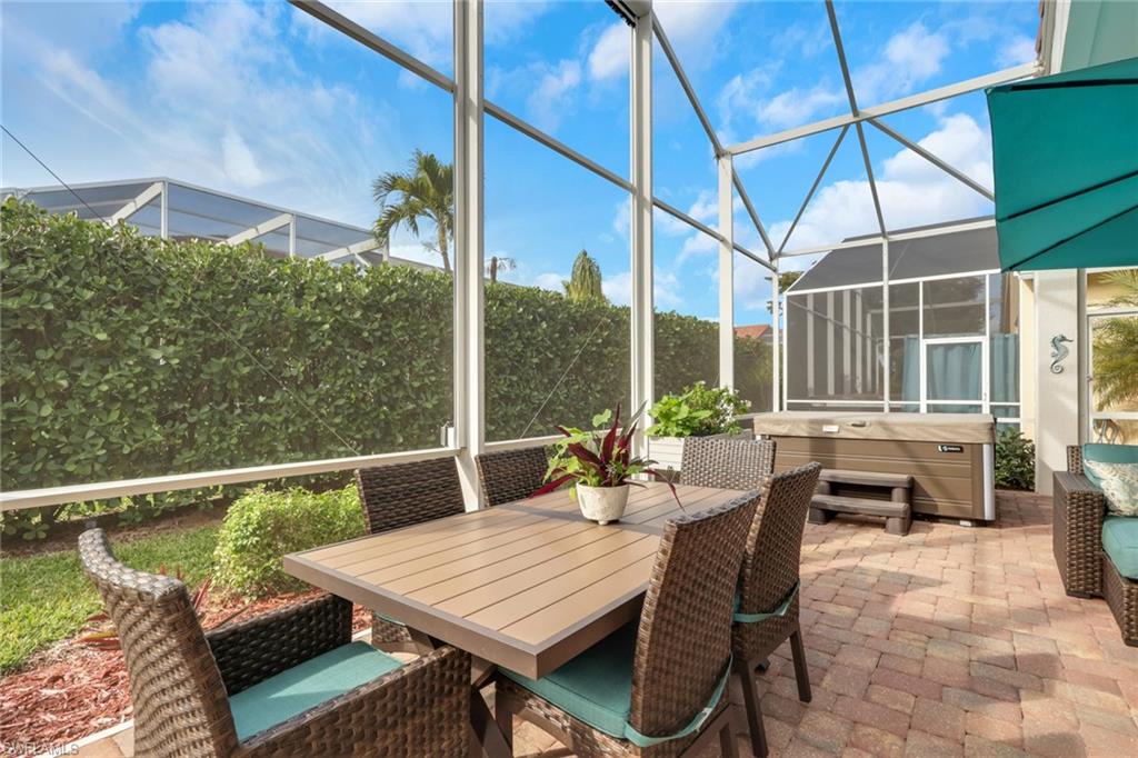 9348 Sun River Way Estero, FL 33928 - Photo 4 of 50 Sunroom / solarium featuring a jacuzzi, a patio, outdoor dining space, and healthy amount of natural light
