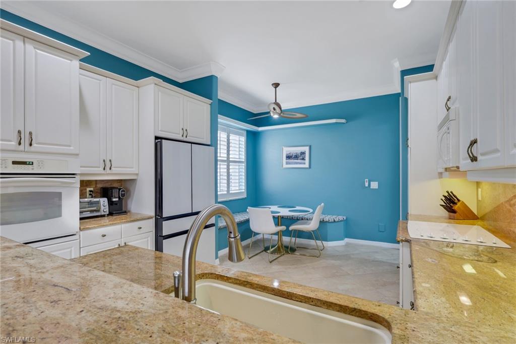 9348 Sun River Way Estero, FL 33928 - Photo 4 of 38 a kitchen with stainless steel appliances granite countertop sink refrigerator and cabinets