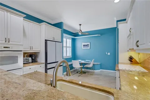 a kitchen with stainless steel appliances granite countertop sink refrigerator and cabinets