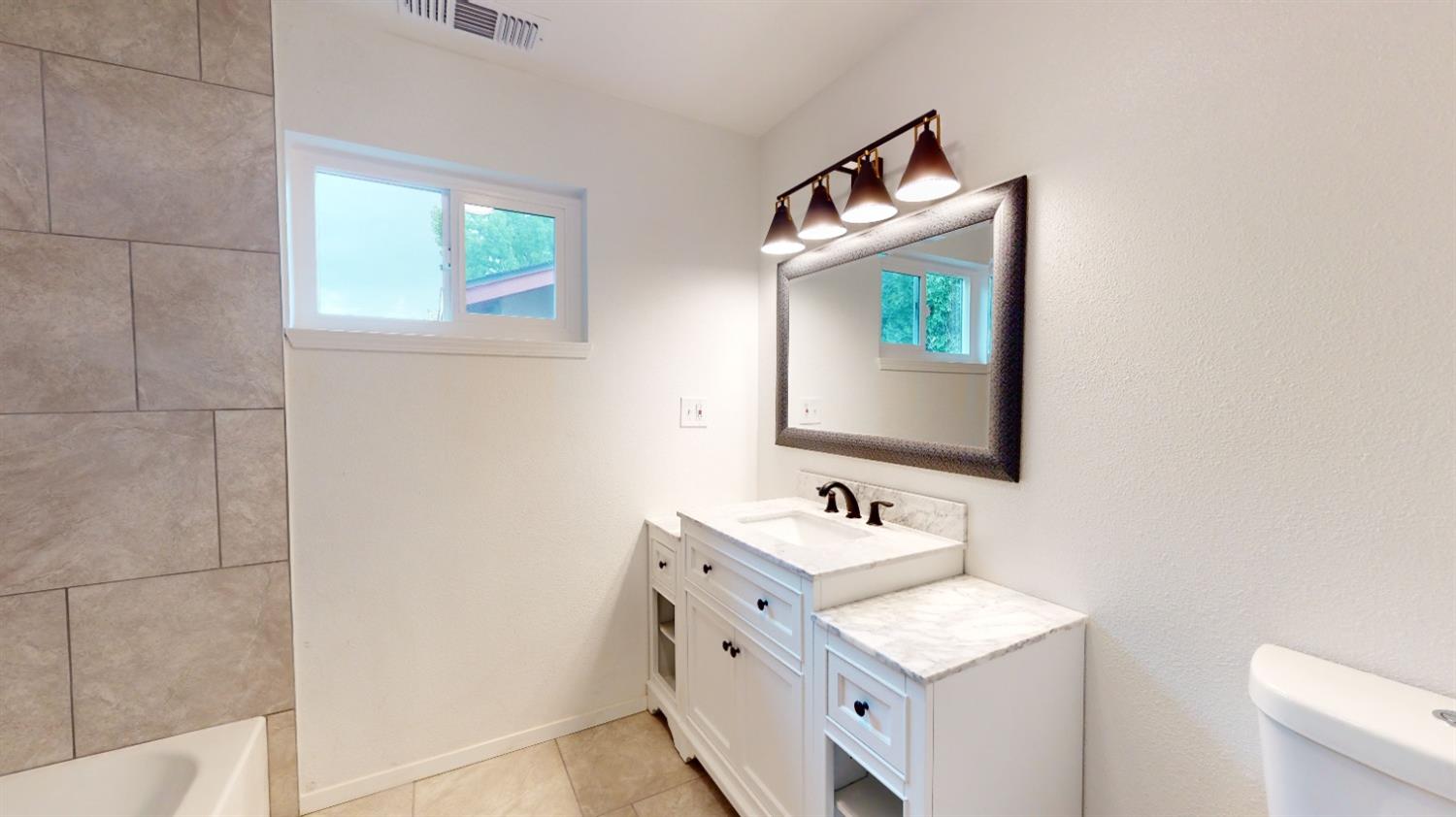 1237 De Cesari Avenue Madera, CA 93637 - Photo 16 of 24 a bathroom with a sink toilet and mirror