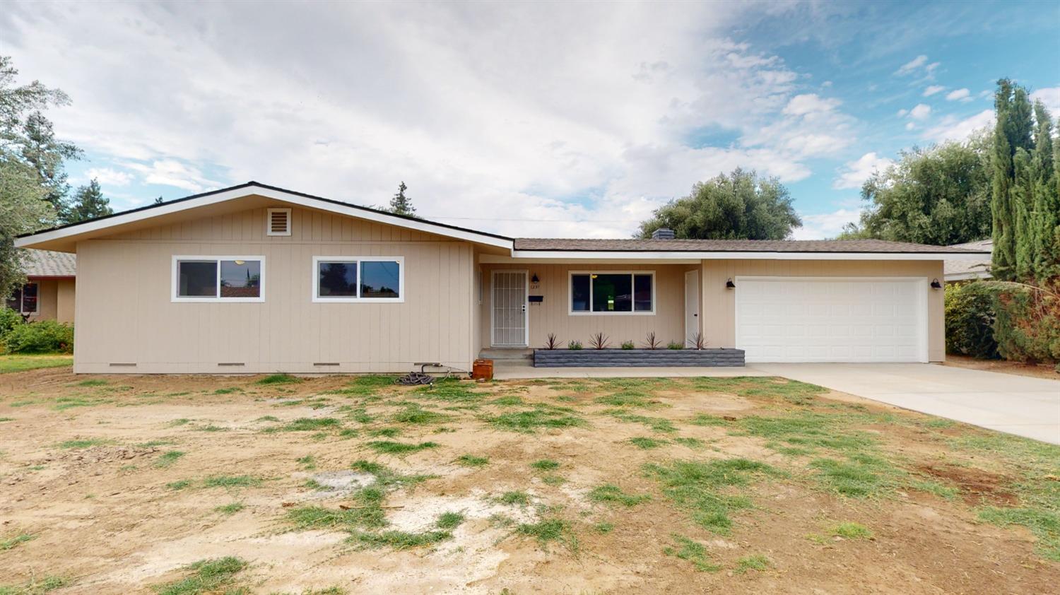 1237 De Cesari Avenue Madera, CA 93637 - Photo 22 of 24 a big house with a large tree in front of it