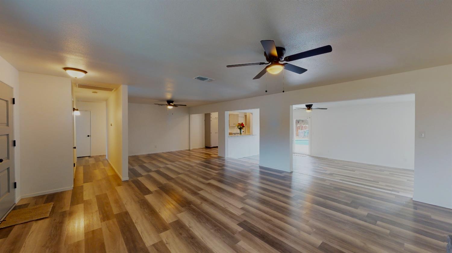 1237 De Cesari Avenue Madera, CA 93637 - Photo 4 of 24 a view of a livingroom with a hardwood floor and a ceiling fan