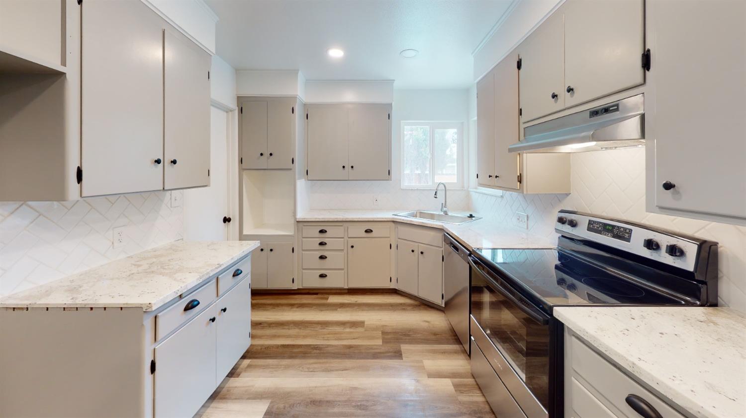 1237 De Cesari Avenue Madera, CA 93637 - Photo 7 of 24 a kitchen with white cabinets and appliances