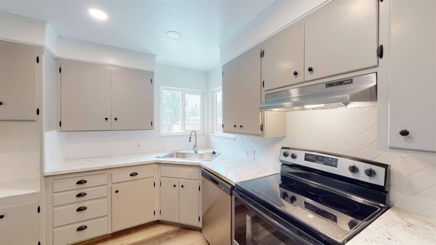 1237 De Cesari Avenue Madera, CA 93637 - Photo 8 of 24 a kitchen with granite countertop a stove and a sink