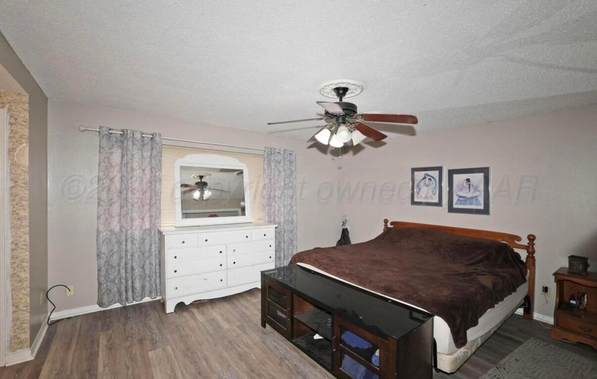 225 Bordeaux Lane Amarillo, TX 79119 - Photo 14 of 25 a bedroom with a bed and a chandelier