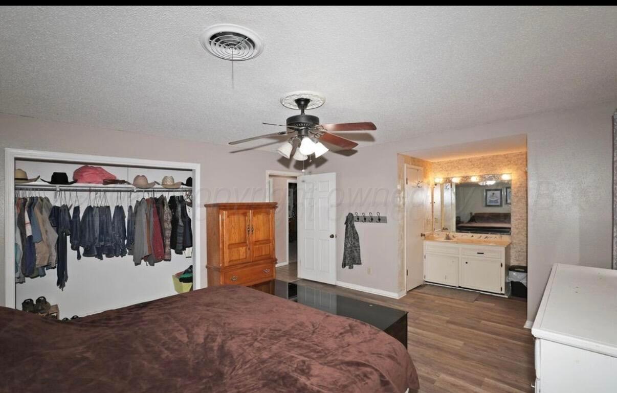 225 Bordeaux Lane Amarillo, TX 79119 - Photo 15 of 25 a view of a bedroom with a bed and wooden floor