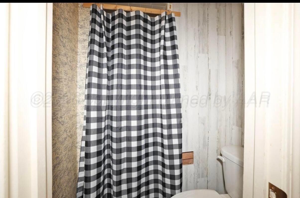 225 Bordeaux Lane Amarillo, TX 79119 - Photo 17 of 25 a bathroom with a black and white shower curtain