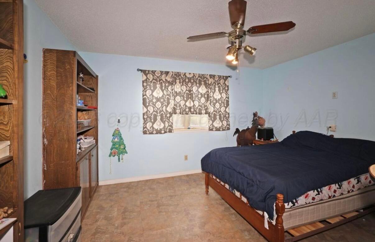225 Bordeaux Lane Amarillo, TX 79119 - Photo 18 of 25 a bedroom with a bed window and a chandelier