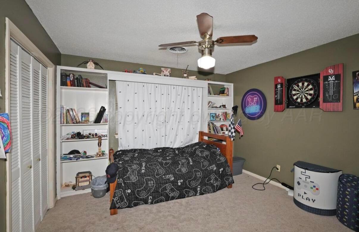 225 Bordeaux Lane Amarillo, TX 79119 - Photo 20 of 25 a bedroom with a bed and a chandelier