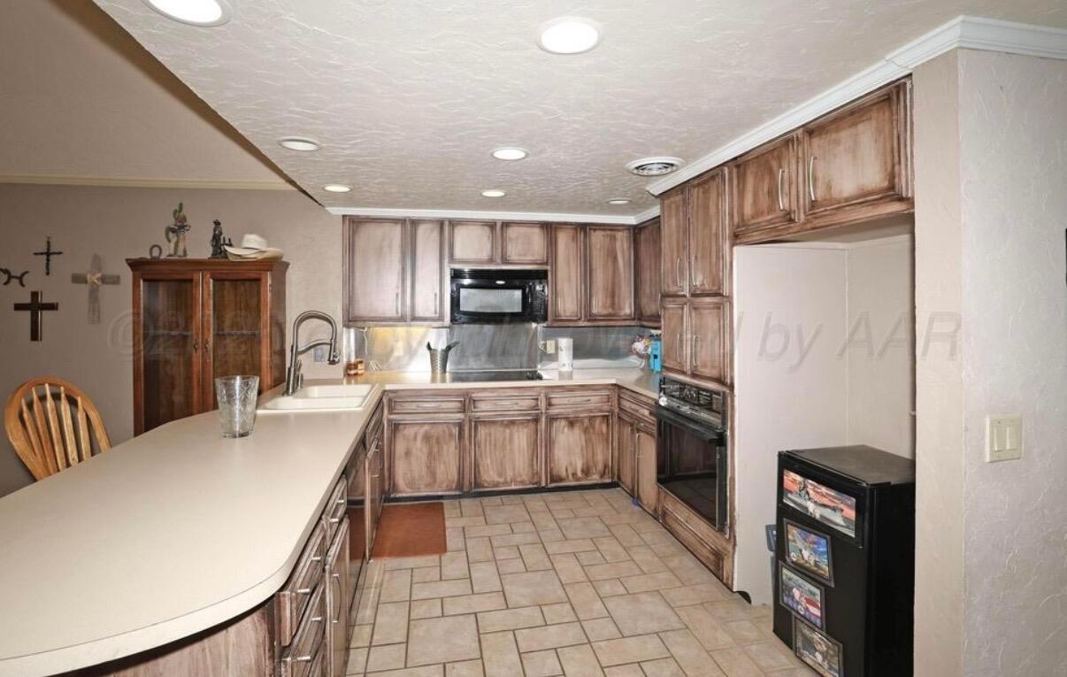 225 Bordeaux Lane Amarillo, TX 79119 - Photo 10 of 25 a kitchen with granite countertop a refrigerator and a sink