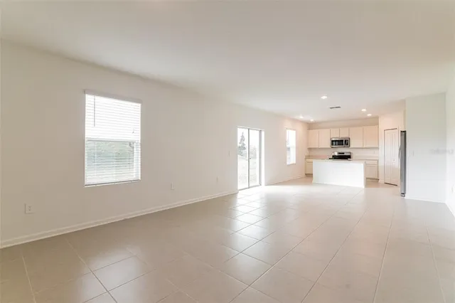 a view of a big room with windows and chandelier