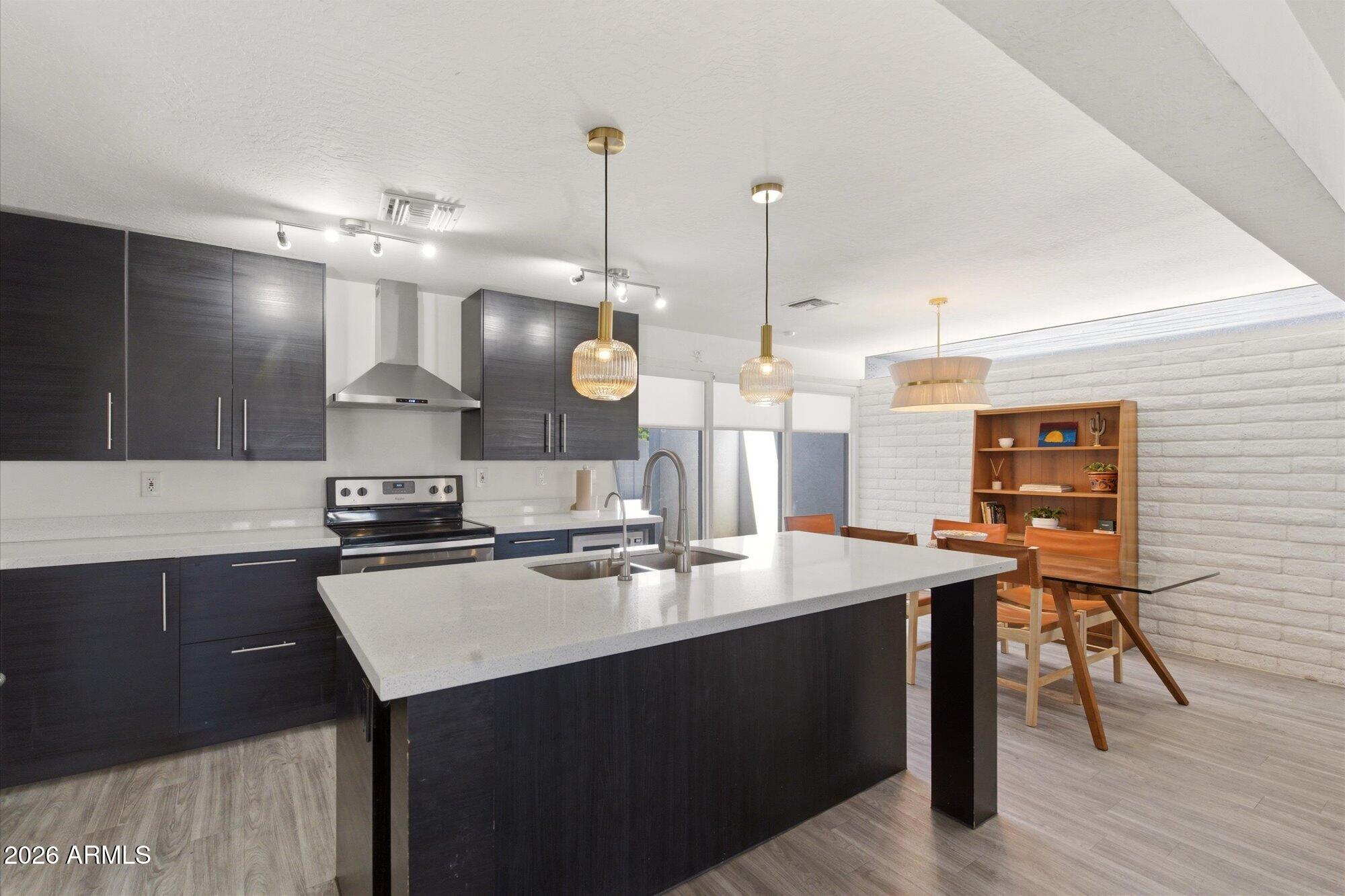 3020 East Wethersfield Road Phoenix, AZ 85032 - Photo 13 of 46 a kitchen with stainless steel appliances kitchen island a sink stove and cabinets