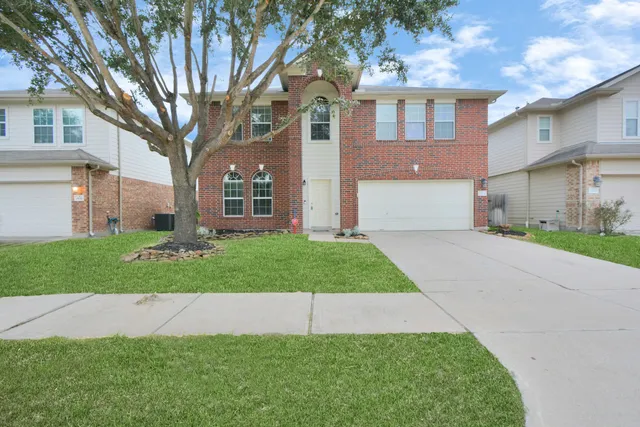 a front view of a house with a garden and yard