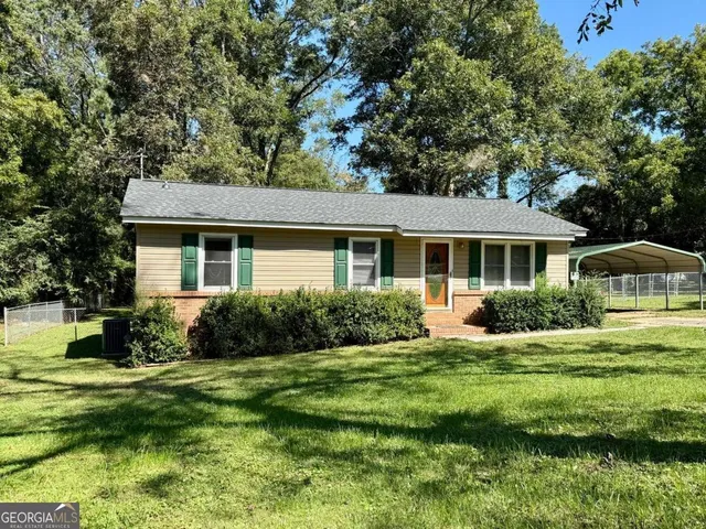 a front view of a house with a yard and trees