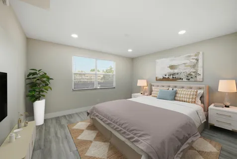 a bedroom with a large bed and a potted plant