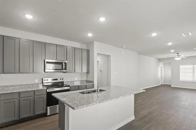 a kitchen with stainless steel appliances granite countertop a sink stove and microwave