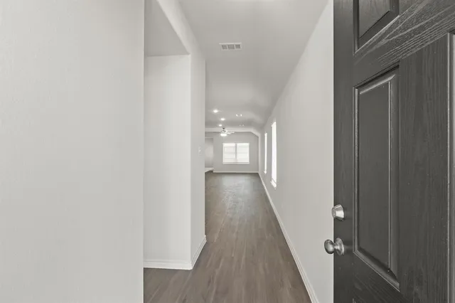 a view of a hallway with wooden floor