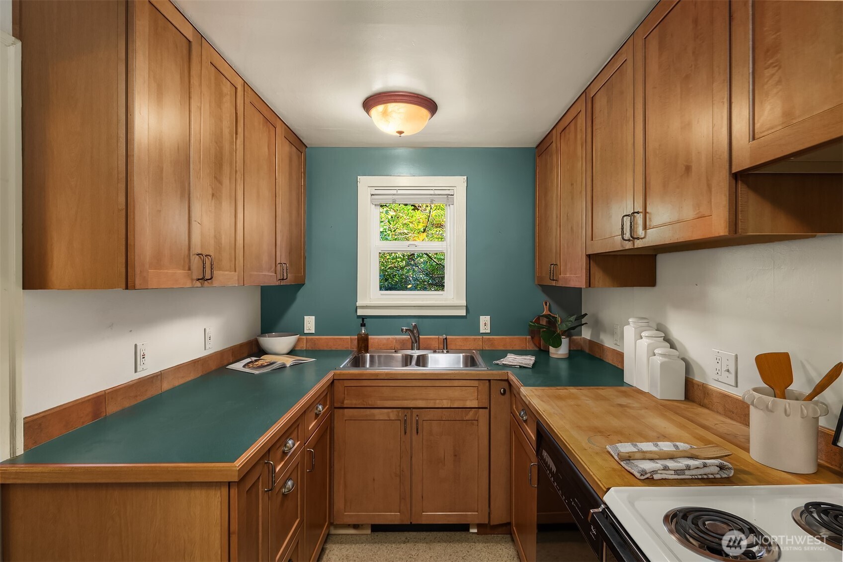 548 Northeast 102nd Street Seattle, WA 98125 - Photo 14 of 27 a kitchen with kitchen island granite countertop a sink stove and cabinets