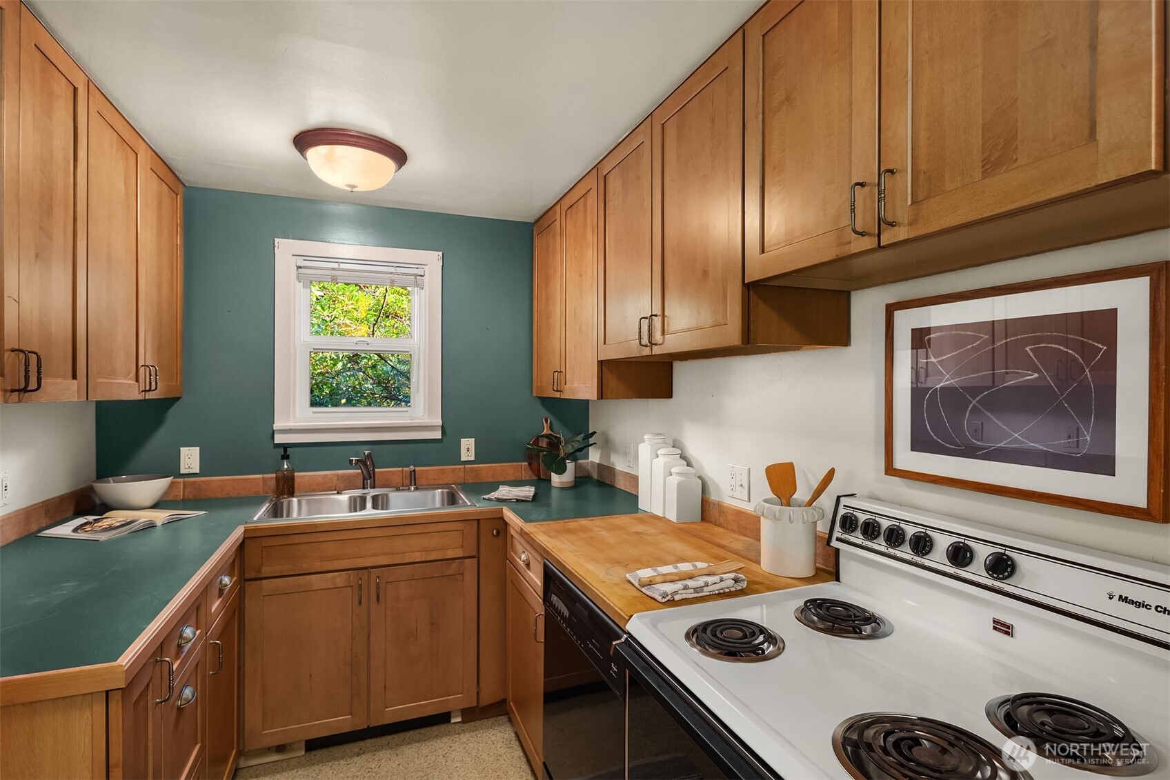548 Northeast 102nd Street Seattle, WA 98125 - Photo 15 of 27 a kitchen with kitchen island granite countertop a sink a stove cabinets counter space and a window