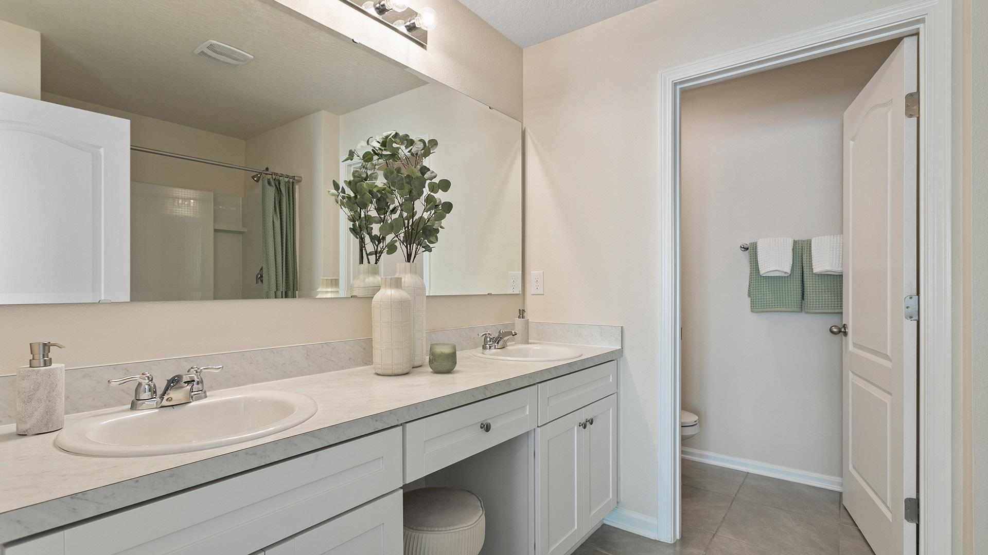 155 Redbud Road Palm Coast, FL 32137 - Photo 19 of 39 a bathroom with a double vanity sink and mirror