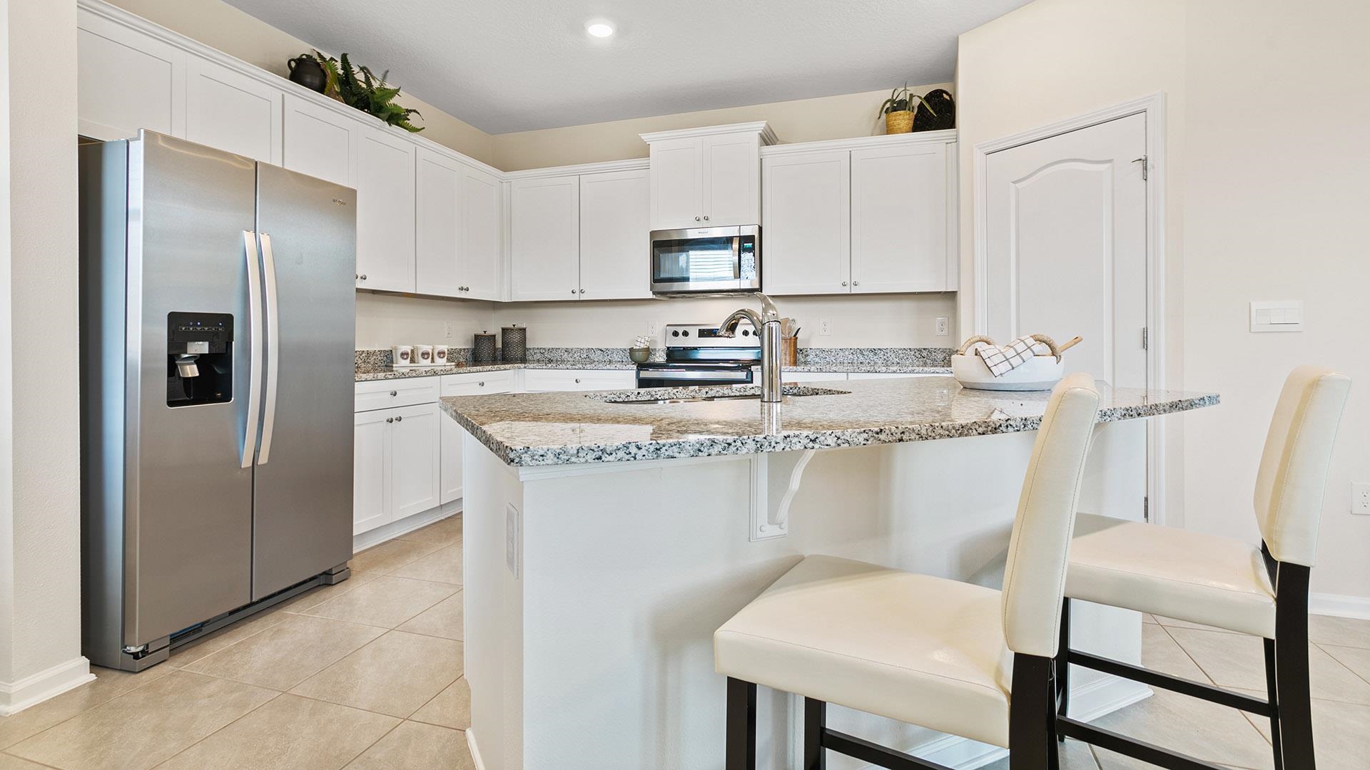 155 Redbud Road Palm Coast, FL 32137 - Photo 7 of 39 a kitchen with stainless steel appliances granite countertop a white refrigerator a sink a stove a dining table and chairs