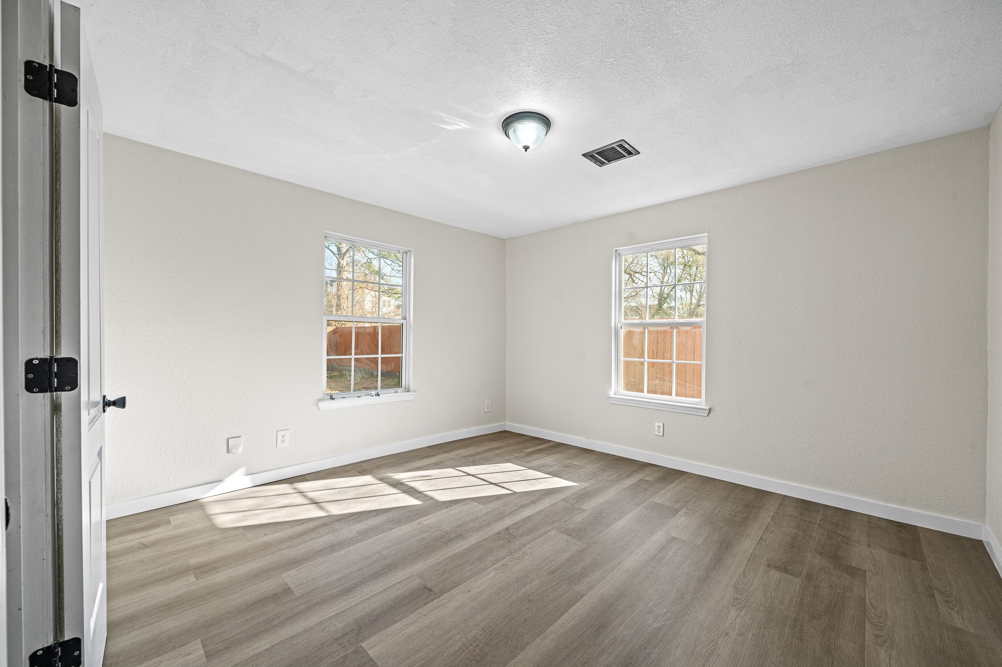 6911 Sherwood Drive Houston, TX 77021 - Photo 11 of 26 a view of an empty room with wooden floor and a window