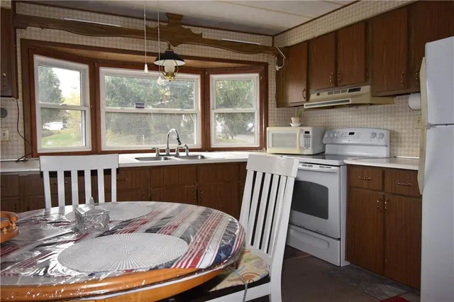 a kitchen with a window dining table and chairs