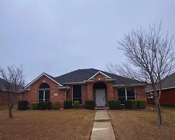 a front view of a house with a yard and trees