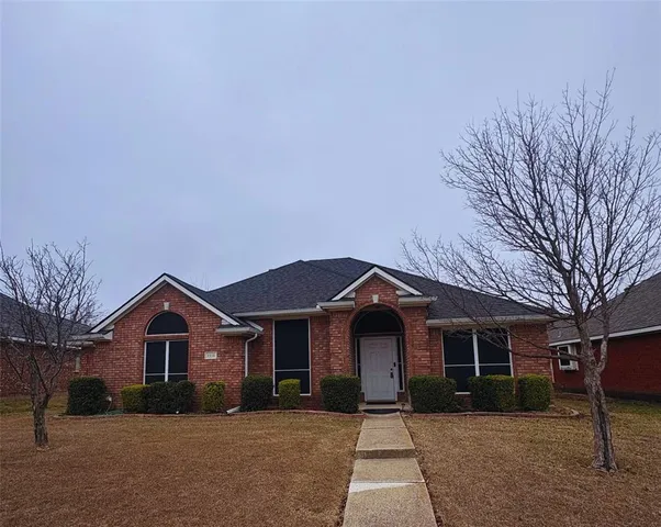 a front view of a house with a yard and trees
