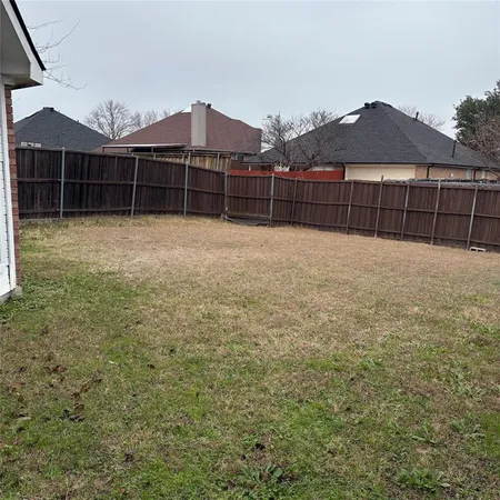 a view of a yard with wooden fence