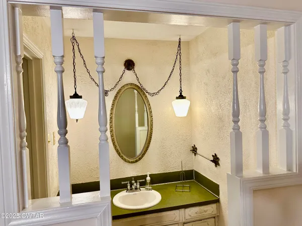 a bathroom with a granite countertop sink a mirror and a shower