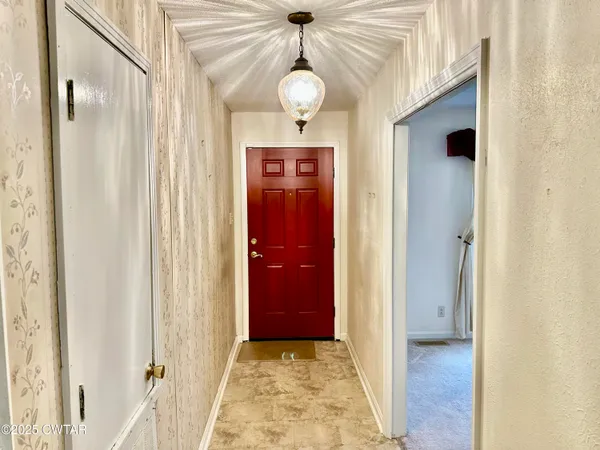 a view of a hallway with wooden floor and front door