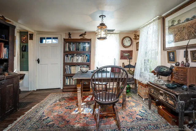 a living room with furniture a bookshelf and a window