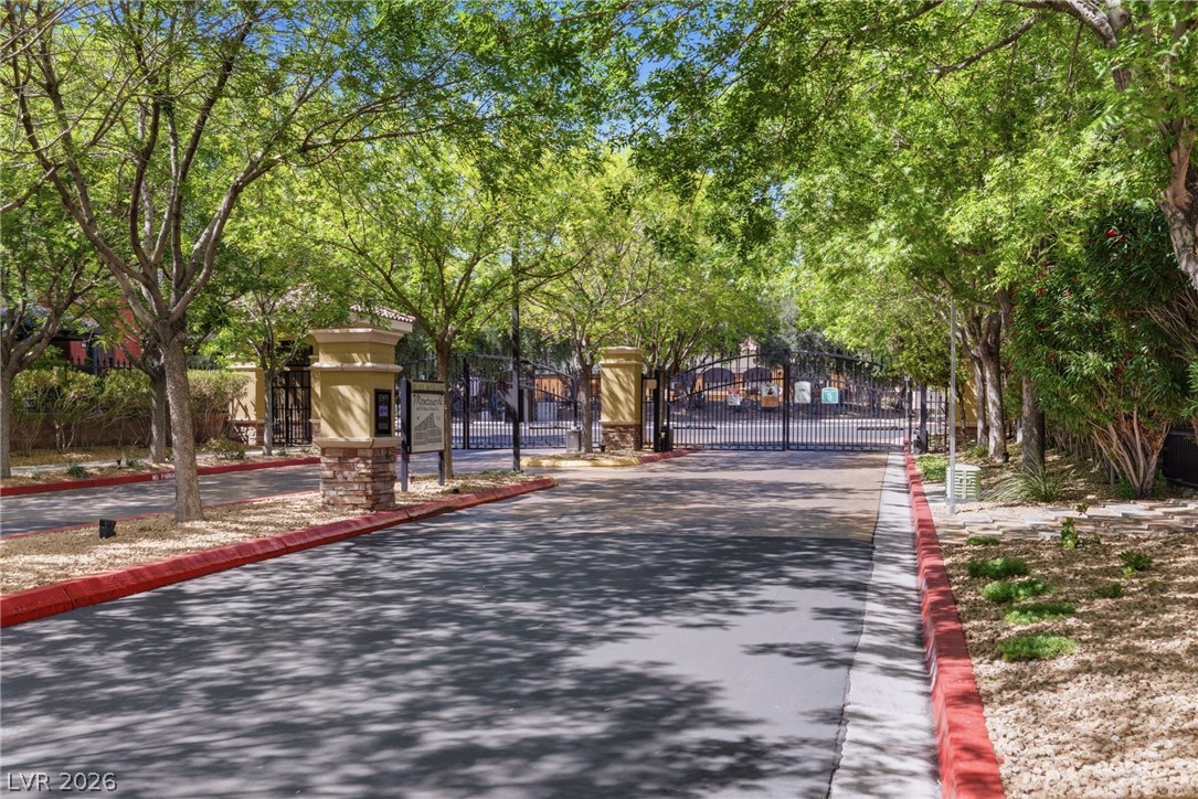 4650 Ranch House Road, Unit 126 North Las Vegas, NV 89031 - Photo 42 of 44 Secure community entrance framed by lush trees, providing both privacy and a welcoming approach.