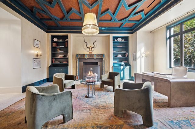 a living room with furniture a fireplace and a large window