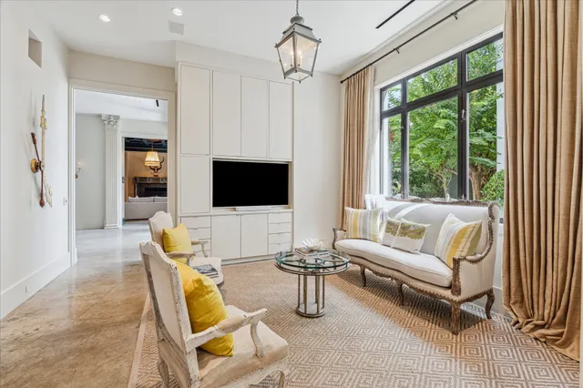 a living room with furniture a flat screen tv and a large window
