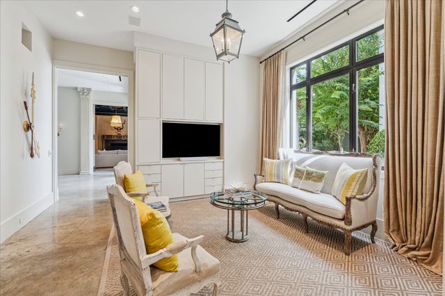 a living room with furniture a flat screen tv and a large window
