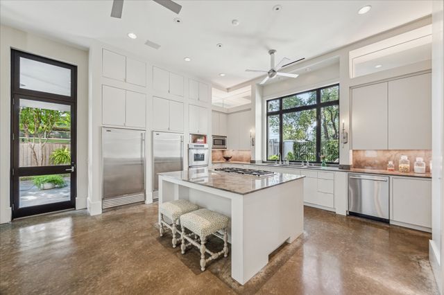a kitchen with a stove a refrigerator and a stove top oven