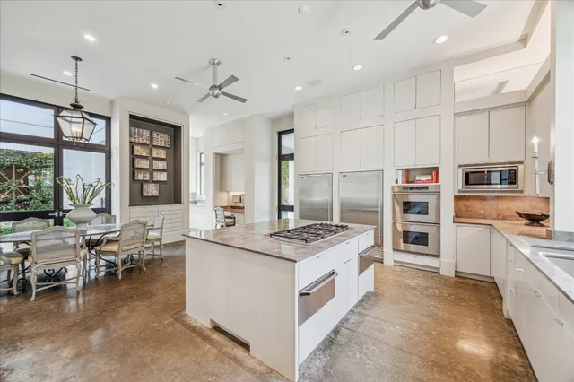 a open kitchen with stainless steel appliances granite countertop a stove oven and a refrigerator with the cabinets