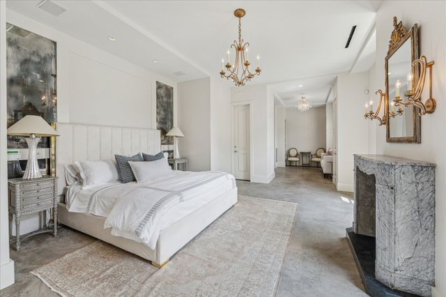 a large bedroom with a bed and a chandelier