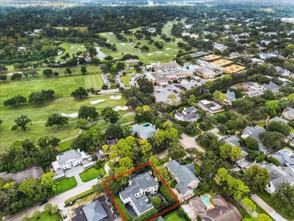 an aerial view of residential houses with outdoor space and trees