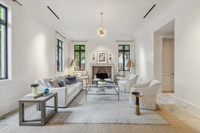 a living room with furniture a fireplace and a chandelier