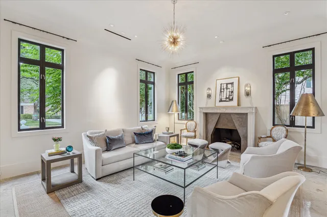 a living room with furniture a chandelier and a fireplace