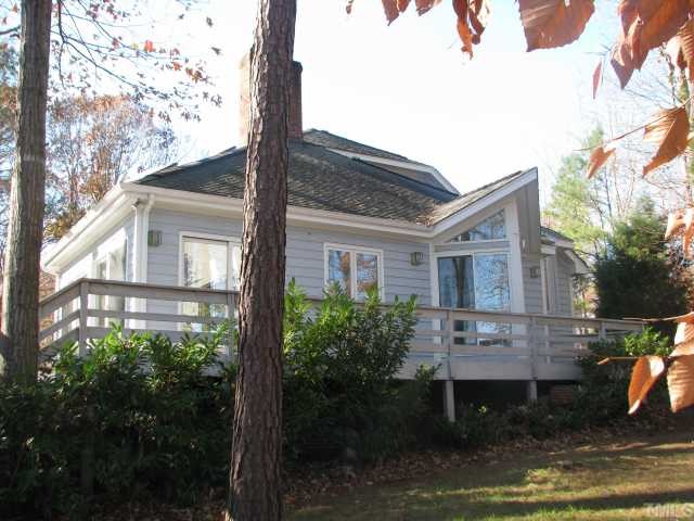 7301 Still Pond Court Raleigh, NC 27613 - Photo 3 of 12 Side view of property, showing more decking around the property. This is the eat in kitchen area behind the large angled window