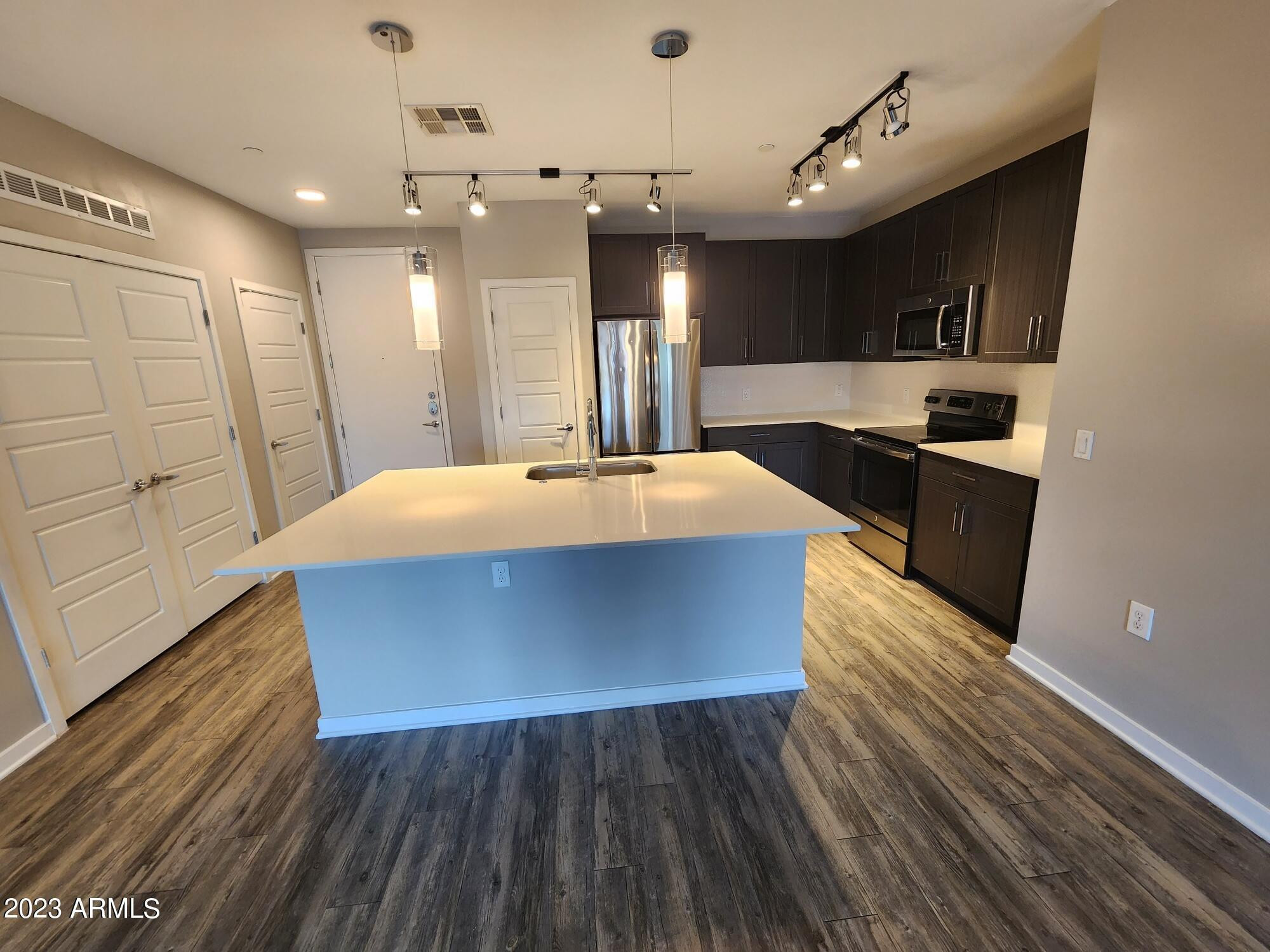200 East Thomas Road, Unit B2 Phoenix, AZ 85012 - Photo 2 of 29 a large kitchen with stainless steel appliances wooden floors and wooden cabinets